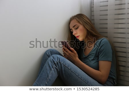 Stok fotoğraf: Young Woman Sitting Anxiously In The Corner