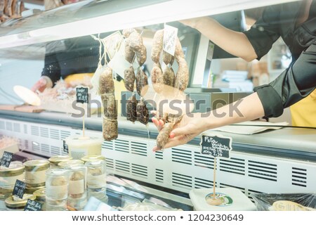 Zdjęcia stock: Sales Girl In Deli At The Meat Counter Cutting Some Sausages