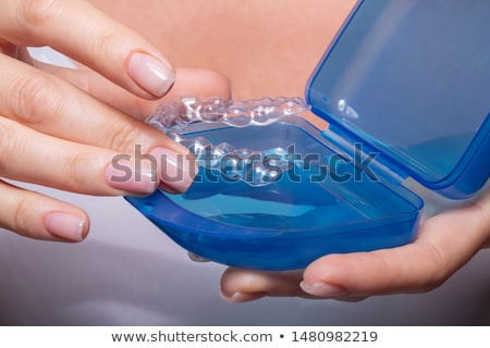 [[stock_photo]]: Woman Putting Aligner In Case