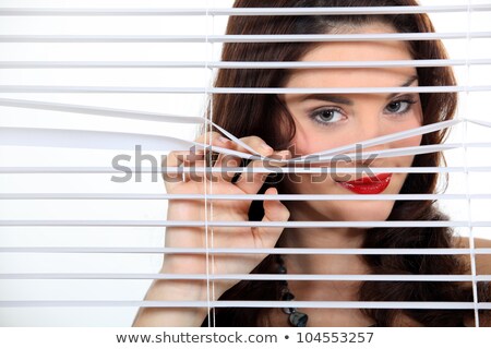 Stock photo: Pretty Woman Behind Blinds Spying Upon Neighbours