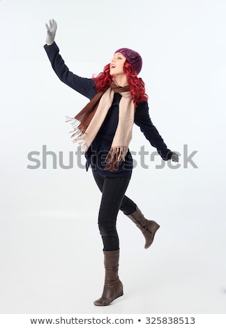 Foto stock: Young Woman Wearing Warm Winter Clothes And Hat Throwing Snowbal