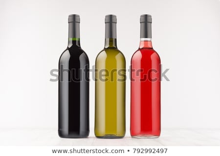 Foto stock: Three Wine Bottles Different Colors - Transparent Green Black  On White Wooden Board Mock Up