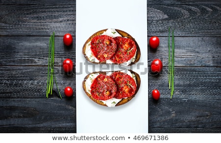 Stock fotó: Toasted Bread Withtomatoes And Cheese Topped With Pepper And Aromatic Green Herbs Over A White Dish