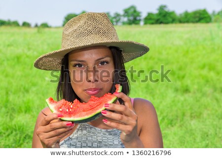 ストックフォト: Woman Wearing Hat Eats Fresh Melon Outside