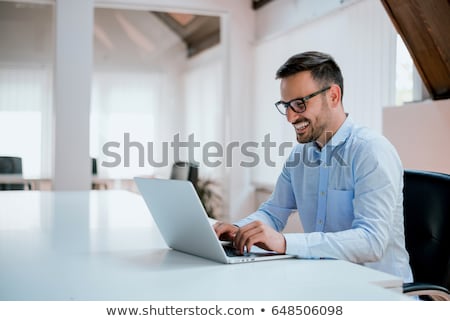 Stok fotoğraf: Young Man Sitting At Desk Portrait