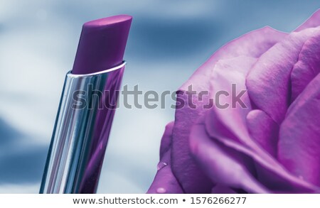 Stockfoto: Purple Lipstick And Rose Flower On Liquid Background Waterproof