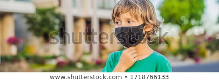ストックフォト: Fashionable Black Medical Mask With Filter In The City Coronavirus 2019 Ncov Epidemic Concept Boy