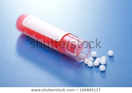 Foto stock: Homeopathic Pills And Container On Red