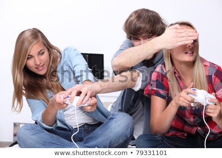 Imagine de stoc: Three Teenagers Sat Playing Video Games