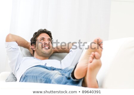 ストックフォト: Smiling Young Man Relaxing And Dreaming On Sofa At Home And Look