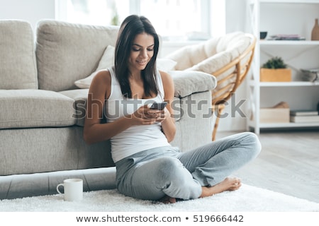 [[stock_photo]]: Happy Young Woman Sitting Barefoot On The Floor