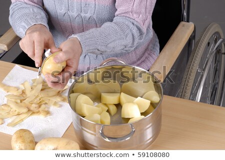 Stock photo: Disabled Adult Woman In Wheelchair Peeling Potatoes