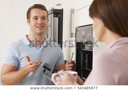 Stockfoto: Engineer Giving Woman Advice On Kitchen Repair