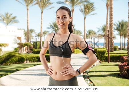 Stock photo: Woman Athlete With Armband Listening To Music On Summer Resort