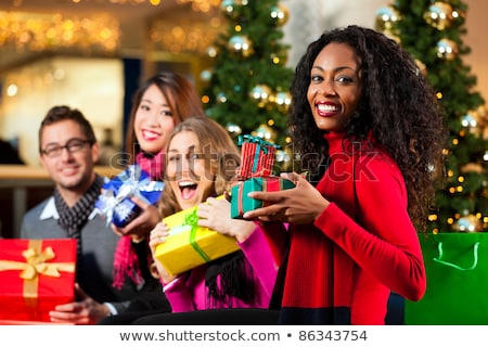 Foto d'archivio: Diversity Friends With Christmas Presents And Bags Shopping In Mall