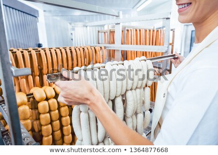 Imagine de stoc: Butcher Woman Showing Sausages On A Rail