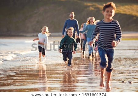 Foto stock: Happy Family Walking Along Autumn Beach