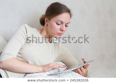 Сток-фото: Caucasian Woman Surfing The Internet Lying On A Sofa