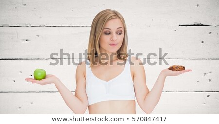 Foto stock: Portrait Of Young Woman Holding Apple And Cookie