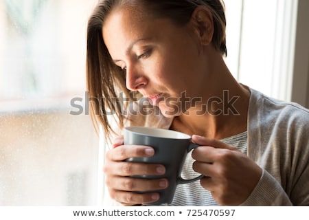 [[stock_photo]]: Lonesome Woman Drinking Coffee In Dark Room