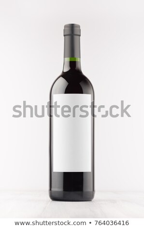 Сток-фото: Black Wine Bottle With Red Wine On White Wooden Board Mock Up Vertical