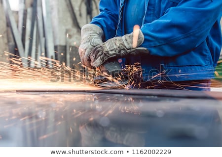 Stockfoto: Worker In Metal Factory Grinding Workpiece With Sparks Flying