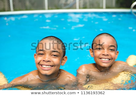 Stok fotoğraf: Portrait Of Twin Brother Boy Having Good Time In Swimming Pool