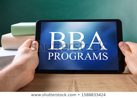 Stock photo: Man Holding Digital Tablet With Bba Programs Words On Screen