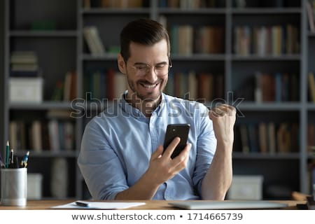 Foto stock: Happy Man Reading News With Smartphone