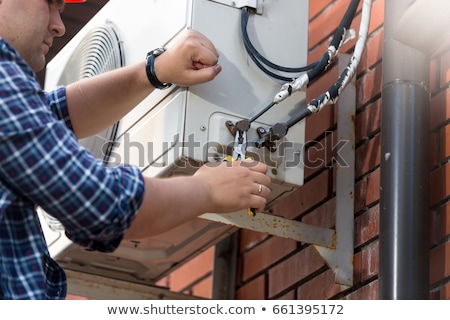 Zdjęcia stock: Male Technician Repairing Air Conditioner Outdoors