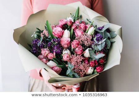 Stock photo: Young Woman Holding Purple Flowers