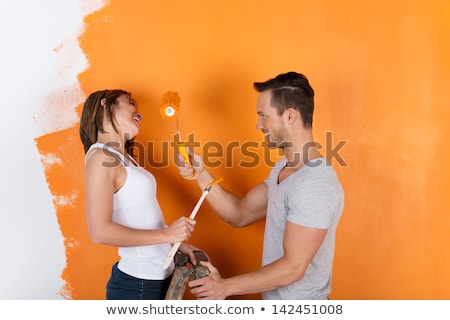 Foto stock: Woman Having Fun Painting Wall