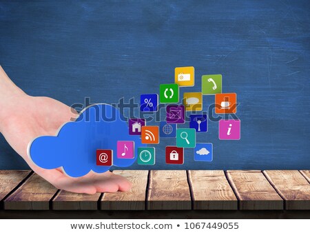 Foto stock: Hand Rest On A Table With Cloud Over And Application Icons Coming Up Form It Blue Wall Behind