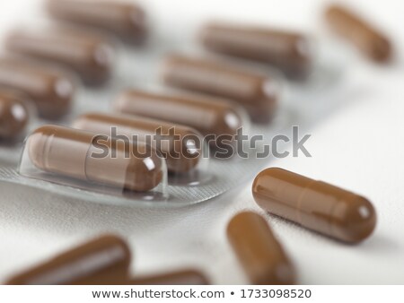 Stock fotó: Pills Capsule In Plastic Strip On White Background Antibiotics Vitamins Painkiller Brown Color