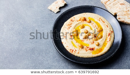 Stok fotoğraf: Hummus Chickpea Dip With Spices And Pita Flat Bread In A Black Plate On Grey Stone Background To