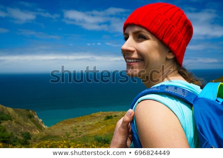 Stock photo: Woman With A Backpack Goes On A Picturesque Hilly Terrain To The