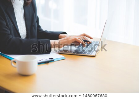 Stok fotoğraf: A Young Girl Is Sitting At The Office At The Table And Typing Text On The Keyboard