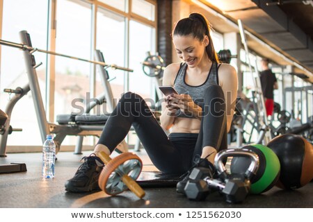 Stock fotó: Smiling Sports Woman In Earphones Holding Smartphone