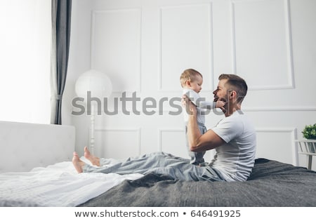 Foto d'archivio: Happy Father Playing With Adorable Baby In Bedroom