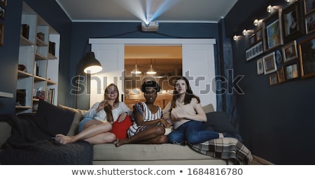 Stockfoto: Friends With Drinks And Snacks Watching Tv At Home