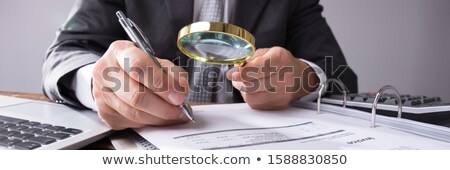 Zdjęcia stock: Auditor Looking At Receipts Through Magnifying Glass