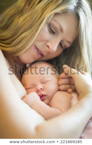 Foto stock: Young Beautiful Mother Holding Her Precious Newborn Baby Girl