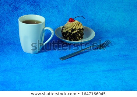 Stockfoto: Cake With Fresh Berries On A Blue Plate Next To A Cup Of Tea And