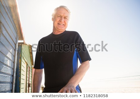 Stok fotoğraf: Portrait Of Senior Man Standing At Beach Hut