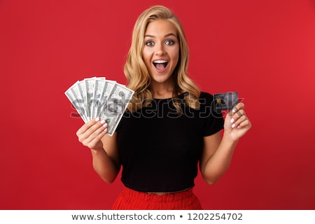 Stock fotó: Excited Woman Holding Money Isolated Over Red Background