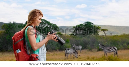 Foto stock: Woman With Backpack And Camera Over Savannah