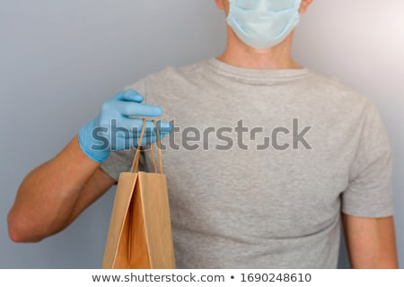 [[stock_photo]]: Courier Delivery Man In Medical Latex Gloves And Mask Safely Delivers Online