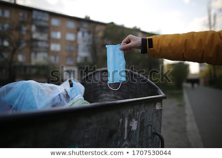 Stok fotoğraf: Man Throwing A Surgical Mask To The Trash Can