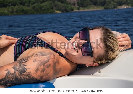 [[stock_photo]]: Emme · blonde · se · faire · bronzer · sur · un · yacht · de · luxe · avec · Bikini