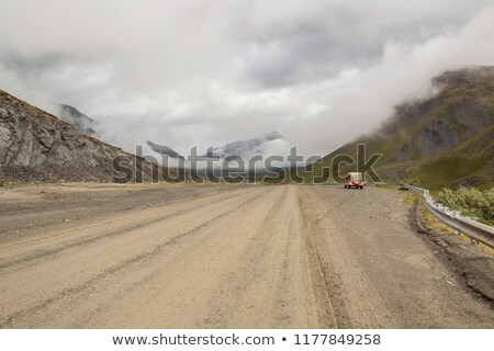 Сток-фото: Fluffy Clouds Over A Gravel Road On A Mountain